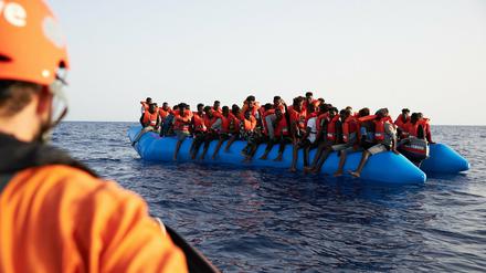 Die von der Seenotrettungsorganisation Sea-Eye herausgegebene Aufnahme zeigt einen Seenotretter, der zu einem Flüchtlingsboot schaut. Potsdam will den Verein nun unterstützen.