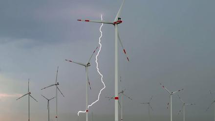 Ein Blitz leuchtet zwischen Windenergieanlagen im Windpark "Odervorland" im Landkreis Oder-Spree in Ostbrandenburg.