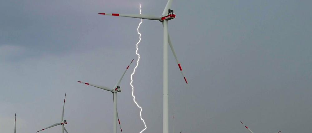 Ein Blitz leuchtet zwischen Windenergieanlagen im Windpark "Odervorland" im Landkreis Oder-Spree in Ostbrandenburg.