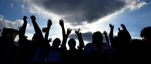 Fußballfans jubeln beim Public Viewing unter freiem Himmel.