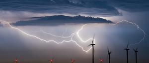 Grelle Blitze erhellen nahe Jacobsdorf (Oder-Spree) ein Feld mit Windkraftanlagen (Archivbild).