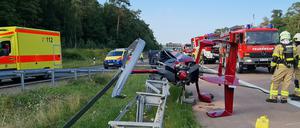 Einsatzkräfte der Feuerwehr stehen an der Absturzstelle eines Tragschraubers am Autobahndreieck Nuthetal. 