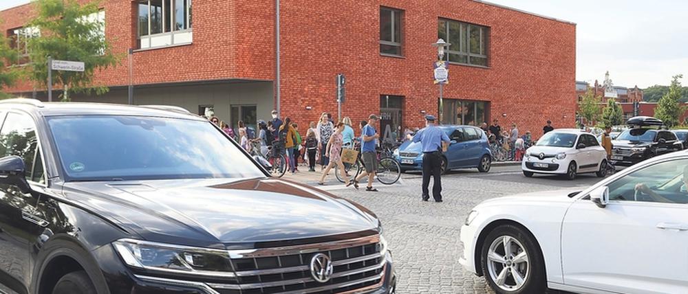 Unübersichtlich. Pkw von allen Seiten, dazwischen Schulkinder zu Fuß und auf Fahrrädern – mit und ohne Eltern.