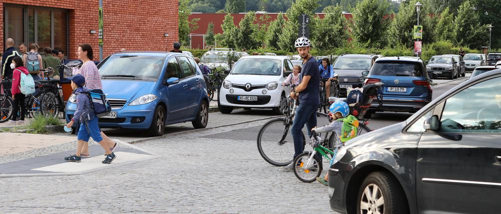 Autos ohne Ende vor der ersten Stunde an der "Grundschule am Jungfernsee" - dazwischen Kinder und Eltern.