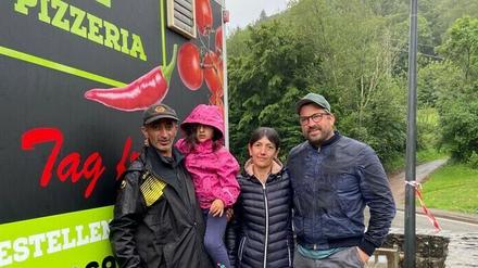 Spendenorganisator Sebastian Frenkel (r.) übergibt einen Pizza-Anhänger an Ahrtal-Einwohner Ali Topalca (l.) und dessen Familie.