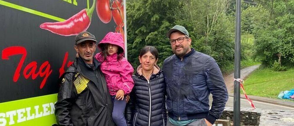 Spendenorganisator Sebastian Frenkel (r.) übergibt einen Pizza-Anhänger an Ahrtal-Einwohner Ali Topalca (l.) und dessen Familie.