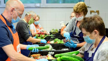 Helfer sortieren vor Beginn der Ausgabe bei der Potsdamer Tafel die Lebensmittel-Spenden aus den Supermärkten.