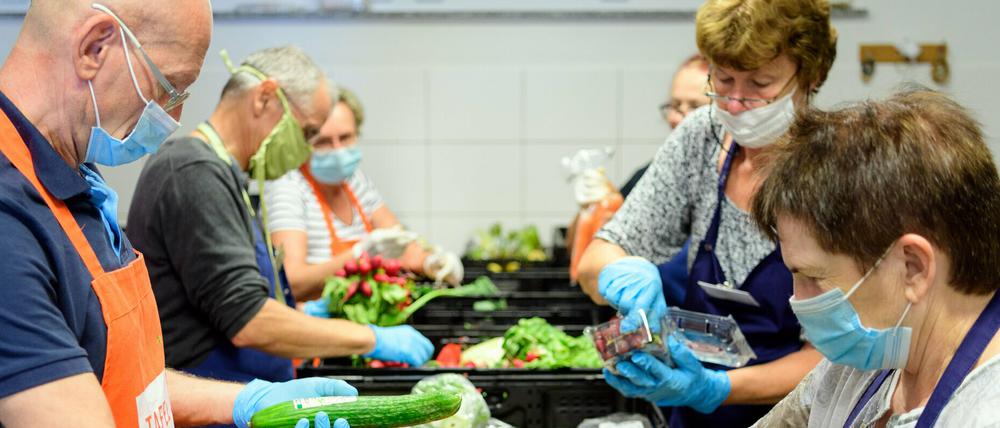 Helfer sortieren vor Beginn der Ausgabe bei der Potsdamer Tafel die Lebensmittel-Spenden aus den Supermärkten.