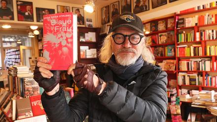 Carsten Wist hält die Literatur hoch, hier den Buchpreisgewinner "Blaue Frau" von Schriftstellerin Antje Ravik Strubel.