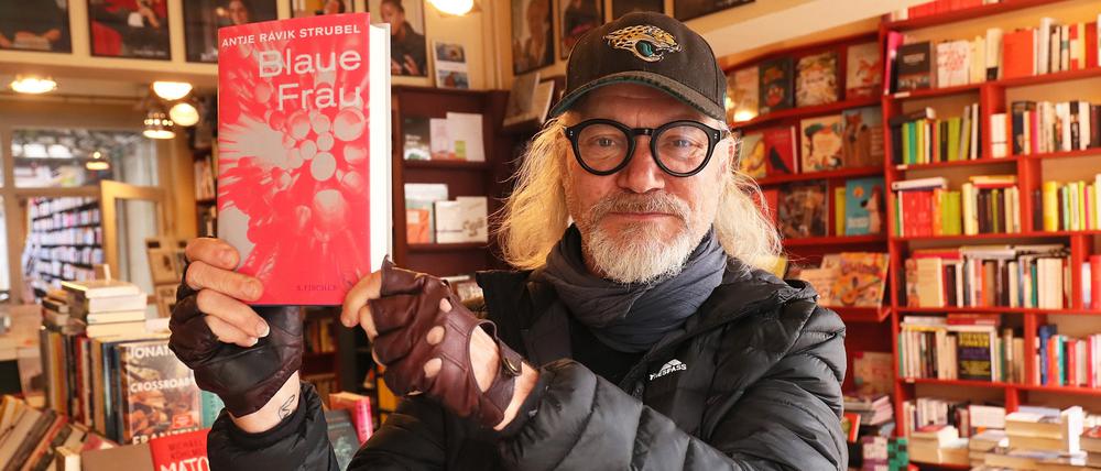 Carsten Wist hält die Literatur hoch, hier den Buchpreisgewinner "Blaue Frau" von Schriftstellerin Antje Ravik Strubel.
