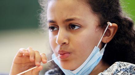 Eine Schülerin bei der Durchführung eines Lolli-Tests.