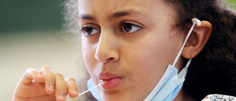 Eine Schülerin bei der Durchführung eines Lolli-Tests.