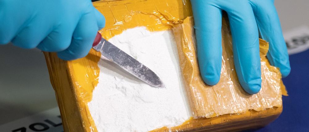 Ein Zollbeamter öffnet ein Paket mit Kokain, das von Beamten sichergestellt wurde. In Potsdam ist ein Kurier bei der Drogenübergabe geschlagen worden. (Symbolbild)