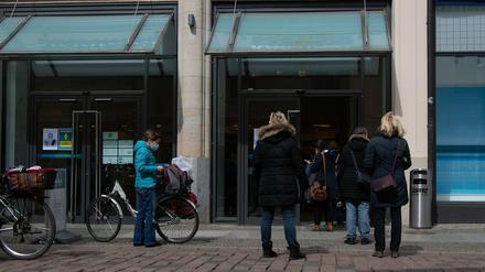 Kundinnen stehen am Eingang der Karstadt-Filiale in Potsdam und warten auf Einlass.