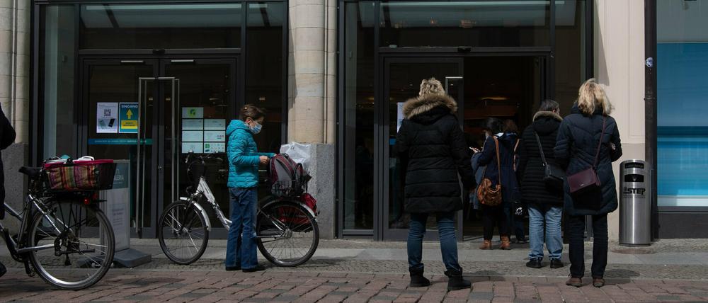 Kundinnen stehen am Eingang der Karstadt-Filiale in Potsdam und warten auf Einlass.