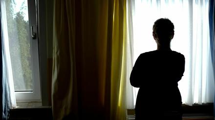 Ein Eine junge Frau im Zimmer eines Frauenhauses (Symbolbild).