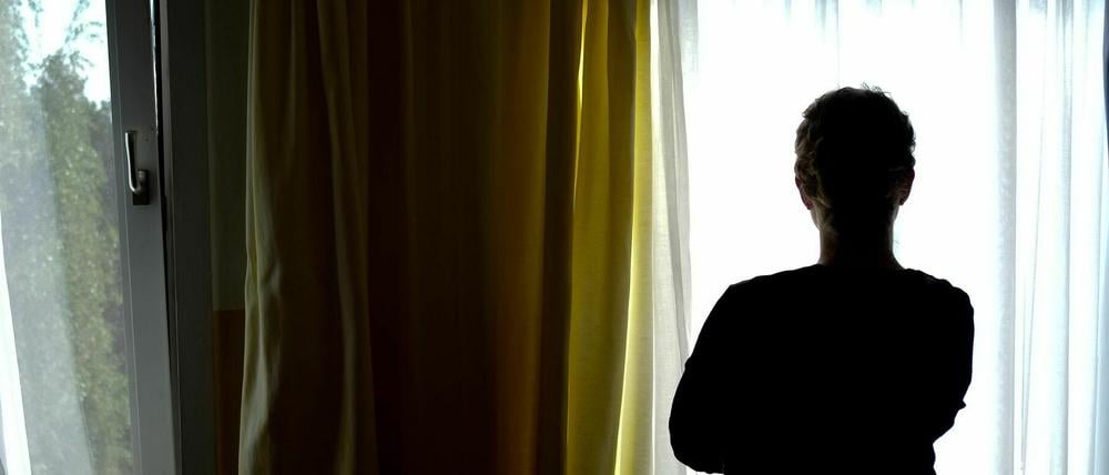 Ein Eine junge Frau im Zimmer eines Frauenhauses (Symbolbild).