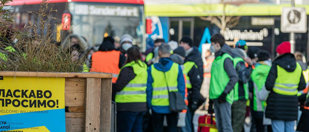 Helfer stehen auf dem Cottbuser Hauptbahnhof und erwarten Flüchtlinge aus der Ukraine.