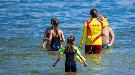 Eine Rettungsschwimmerin mit Kindern eines Schwimmkurses. Auch Erwachsene sollten ihre Fähigkeiten auffrischen (Archivbild).