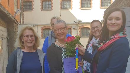 Jeanette Toussaint (Mitte) erhält in der Gedenkstätte Lindenstraße den Hexenbesen 2022 vom Autonomen Frauenzentrum Potsdam.