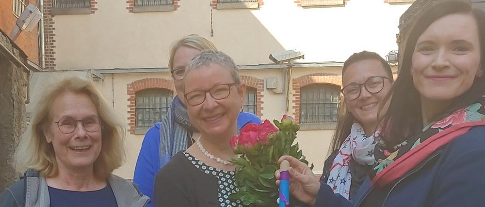 Jeanette Toussaint (Mitte) erhält in der Gedenkstätte Lindenstraße den Hexenbesen 2022 vom Autonomen Frauenzentrum Potsdam.