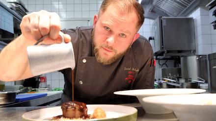 Kochzimmer-Chefkoch David Schubert zeigt Kalbsbäckchen und Blumenkohl unter Soße und Brotring.