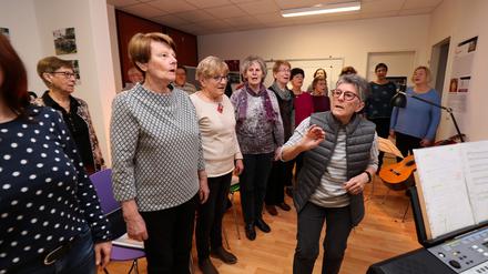 Chorleiterin Doris Appel-Weyhrauch (rechts) hält die Sänger auf Trab. Im November vergangenen Jahres hat sie den Chor im Bornstedter Feld gegründet. Einmal wöchentlich treffen sich die Teilnehmer im Stadtteilladen zum gemeinsamen Singen.
