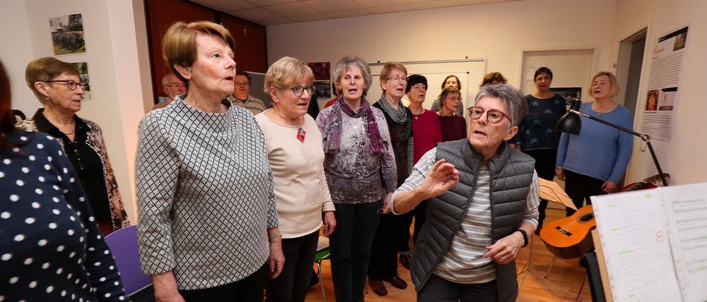 Chorleiterin Doris Appel-Weyhrauch (rechts) hält die Sänger auf Trab. Im November vergangenen Jahres hat sie den Chor im Bornstedter Feld gegründet. Einmal wöchentlich treffen sich die Teilnehmer im Stadtteilladen zum gemeinsamen Singen.