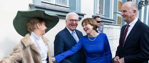 Bundespräsident Frank-Walter Steinmeier, seine Frau Elke Büdenbender und Brandenburgs Ministerpräsident Dietmar Woidke (SPD, r.) unterhalten sich zur Eröffnung des Fontanejahres 2019 bei einem Stadtrundgang in Neuruppin mit einer Drehorgelspielerin.
