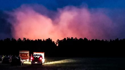 Einsatzfahrzeuge stehen am Montagabend vor der Brandstelle in Jüterbog.