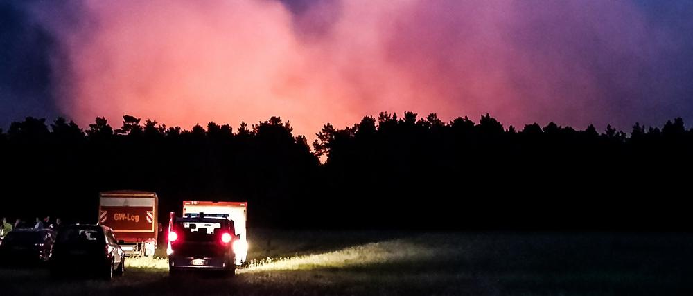 Einsatzfahrzeuge stehen am Montagabend vor der Brandstelle in Jüterbog.