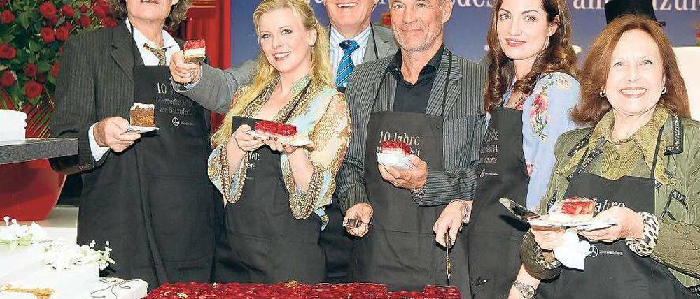 An der Schnittstelle. Walter Müller, Chef der Berliner Mercedes-Niederlassung (3. v. r.) holte sich bekannte Unterstützer für das Verteilen der Geburtstagstorte: Mit dabei waren unter anderen Winfried Glatzeder (v.l.n.r.), Eva Habermann, Heiner Lauterbach, Natalia Wörner und Brigitte Grothum. Foto: Davids/Huebner