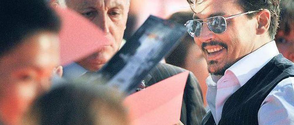 Schriftkünstler. Schon bei der Premiere in Tokio war Johnny Depps Autogramm hochbegehrt. Vor dem Cinestar am Potsdamer Platz dürfte dies kaum anders werden. Schon am Freitagvormittag versammelten sich dort die Fans. Foto: AFP