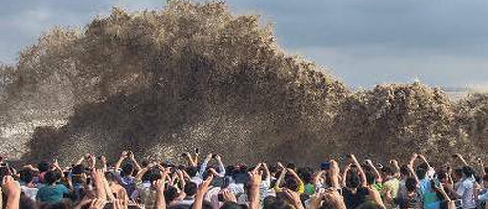 Vor dem großen Sturm. Besucher in Hangzhou fotografieren die hohen Wellen, die bereits gestern gegen die Kaimauer der Stadt schlugen. Foto: Reuters