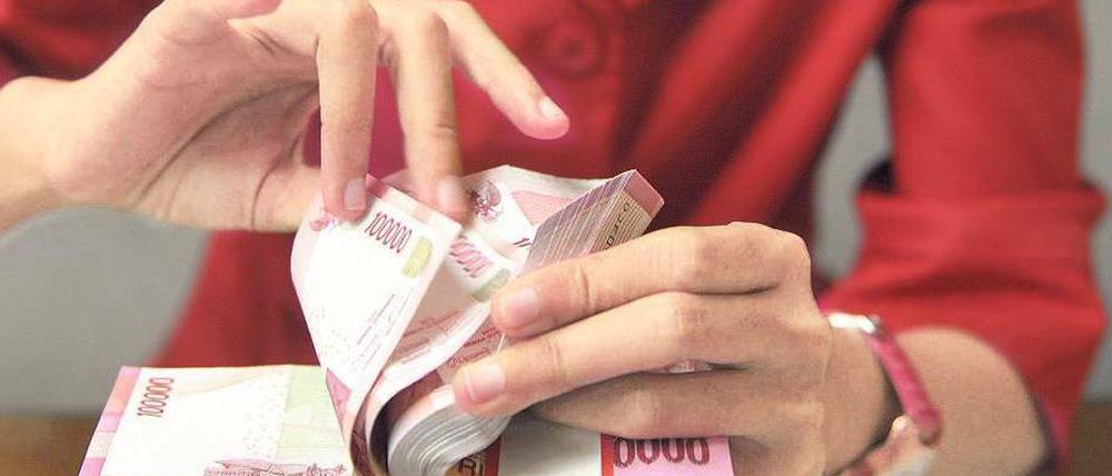 Geld wechseln. Die indonesische Wirtschaft, die größte in Südostasien, wuchs 2013 so langsam wie zuletzt vor vier Jahren.