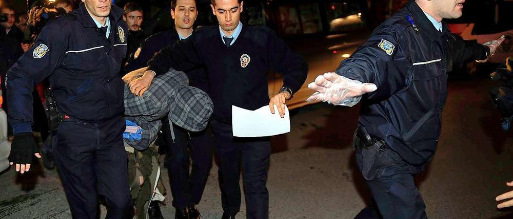 Polizisten führen den verhinderten Flugzeugentführer ab.