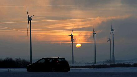 Windräder vor Sonnenuntergang - wie sieht die Zukunft der großen Stromkonzerne aus?