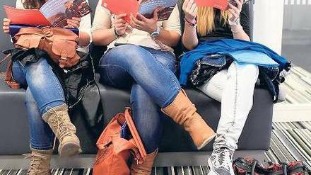 Bereit zur Auswanderung. Drei junge spanische Krankenschwestern lesen Broschüren mit Informationen über einen Neustart in einem anderen europäischen Land. Denn die Krise in Spanien dürfte noch länger anhalten.