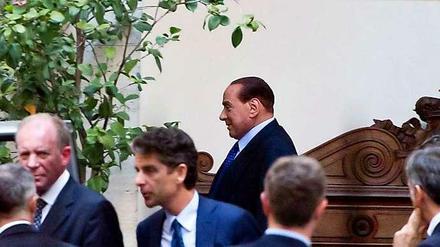 Silvio Berlusconi (hinten) am Freitag beim Verlassen seines Wohnsitzes in Rom.