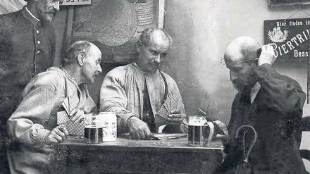 Männer beim Skat. Das Foto entstand um das Jahr 1900 herum. Bis heute wird das Kartenspiel in Wirtshäusern gespielt. Doch seit dem Jahr 2000 hat es auch online im Internet seinen Siegeszug angetreten. Dem organisierten Skat fehlt aber die Jugend. 