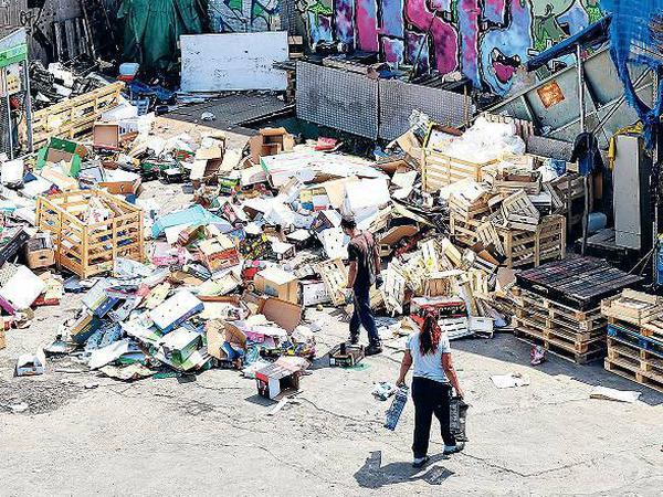 Wertstoffhof. Aus diesem Haufen müssen Holz und Pappe getrennt werden. Rechts im Bild: das Förderband zur Presse.