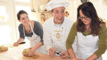 Ein bisschen Spaß muss sein. Mit Freude Stollen backen, das zeigt der Dresdner Meister Henry Mueller den Teilnehmerinnen bei seinem Kurs.