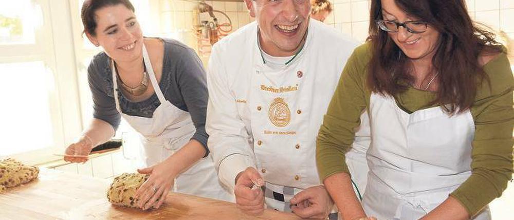 Ein bisschen Spaß muss sein. Mit Freude Stollen backen, das zeigt der Dresdner Meister Henry Mueller den Teilnehmerinnen bei seinem Kurs. 
