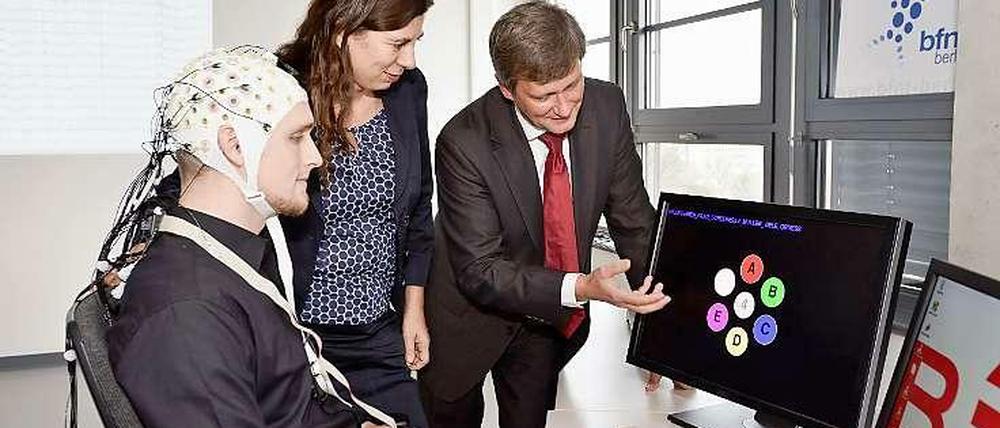 Ausgezeichnet. Klaus-Robert Müller erläutert Wissenschaftssenatorin Sandra Scheeres wie das EEG-basierte Kommunikationssystem funktioniert: In den abgeleiteten Hirnströmen werden Muster identifiziert. Sie zeigen, auf welchen Buchstaben sich der Proband konzentriert.