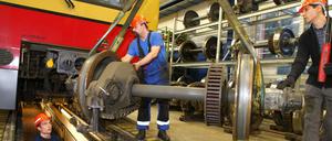 Mitarbeiter reparieren die Achsen eines S-Bahn-Wagens.