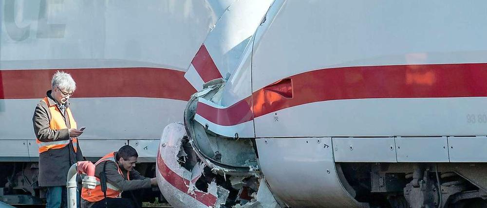 Bahntechniker begutachten den Schaden an den Zügen.