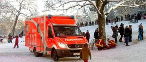 Retter im Park. Sanitäter versorgen das Unfallopfer.