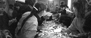 Erfurter Bürger drängen sich am 4. Dezember 1989 in der Stasi-Bezirksverwaltung um einen Tisch mit zerrissenen Unterlagen. 