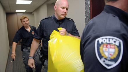 Grausiger Fund. Polizisten tragen das Paket mit dem menschlichen Fuß aus der Zentrale der Konservativen Partei in Ottawa.