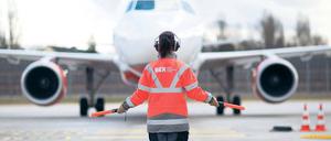 Gib mir ein Zeichen. Janine Kersten winkt als „Marshaller“ mit ihren Leuchtstablampen auf und ab. Je schneller, desto mehr Schub gibt der Pilot geradeaus in Richtung der Parkposition vorm Tegeler Terminal C. Längere Maschinen dürfen weiter vor. Alles, was touchiert oder eingesaugt werden könnte, musste vorher weg. Fotos: Georg Moritz